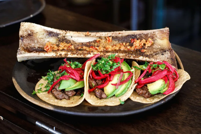 Delicious Mexican tacos with beef, avocado, and pickled onions served with bone marrow in Ciudad de México.